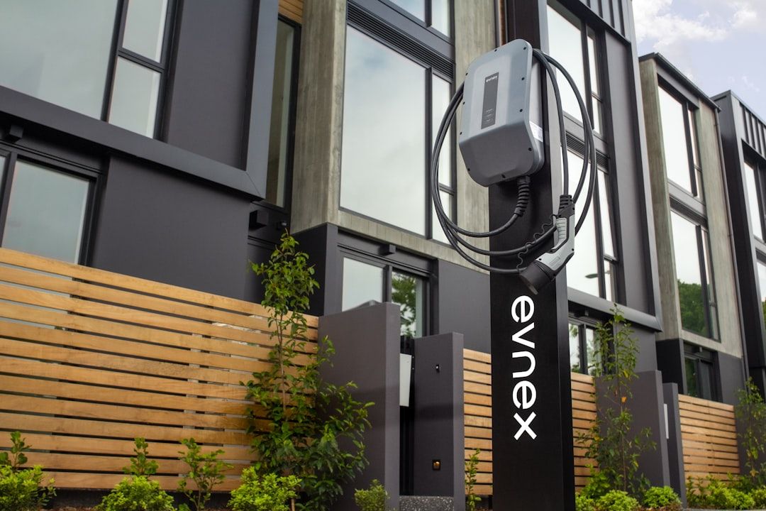 Evnex-sähköauton latausasema modernin asuinkerrostalon edustalla.